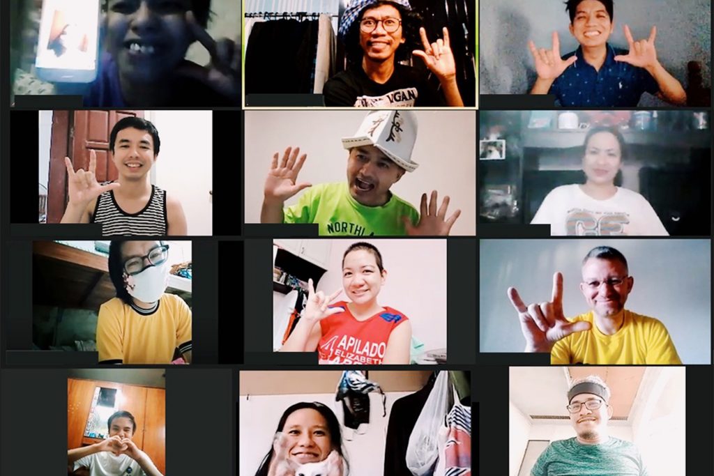 People on an online video call, making hand signs
